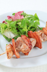 Pork skewer with salad greens