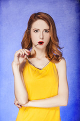 Fototapeta premium American redhead girl in sunglasses. Photo in 60s style.