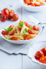 Pasta salad with fresh cherry tomatoes on kitchen table