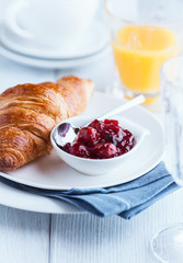 Croissant with sour cherry jam on a plate