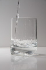 agua en vaso y copa de cristal