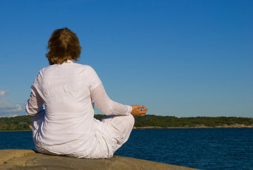 Frau beim Meditieren am Meer