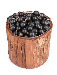 Black currant in wooden cup isolated on white