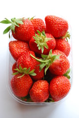 Strawberries in plastic box on white background