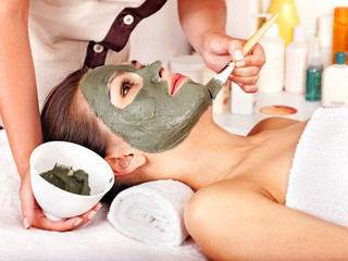 Clay facial mask in beauty spa.