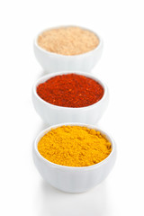  Different spices in white bowls isolated on white background.