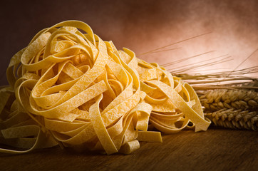 group of italian homemade pasta tagliatelle on wood