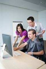 Dynamic trio working at a desktop computer