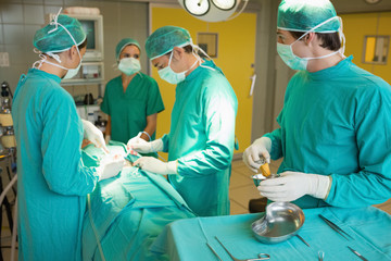 Serious team operating a patient