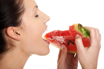 Happy young beautiful woman is eating watermelon.