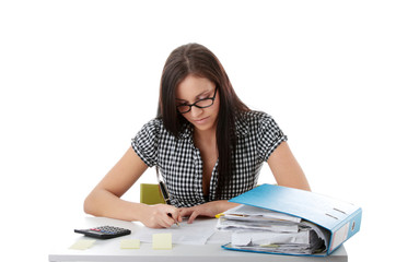 Young woman in glasses sitting at desk and working
