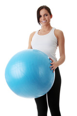 Young woman holding fitness ball with smile