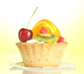 sweet cake with fruits on yellow background