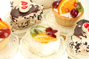 sweet cakes with fruits and chocolate isolated on white