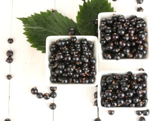 Fresh black currant in wooden bowls