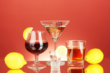 a variety of alcoholic drinks on red background