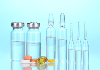 Tablets and ampoules on blue background