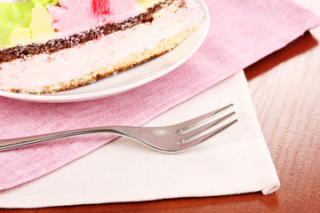 Creamy cake on saucer on table close-up