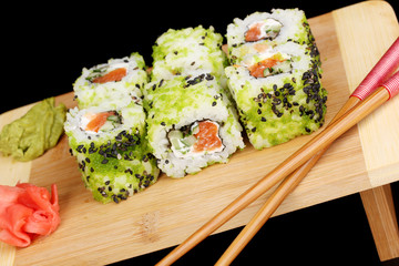 Tasty rolls served on wooden plate isolated on black