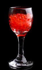 Red caviar in glass isolated on black