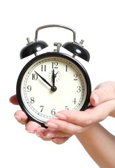 alarm clock in a female hand on a white background