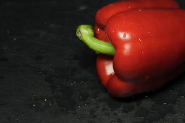 Red paprika on dark slate