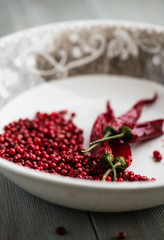 Bowl of pink peppercorns and dried chili peppers