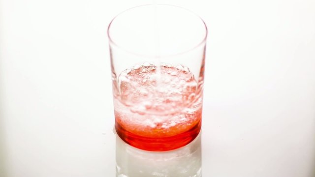 Acqua frizzante in bicchiere rosso