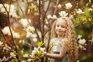 Fototapeta premium Beautiful girl and blooming magnolia tree