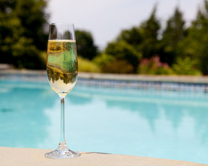 Flute of cold champagne by side of pool