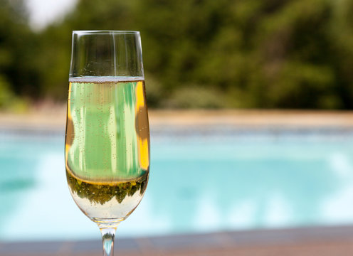 Flute of cold champagne by side of pool