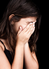 Beautiful hispanic girl crying and covering her face