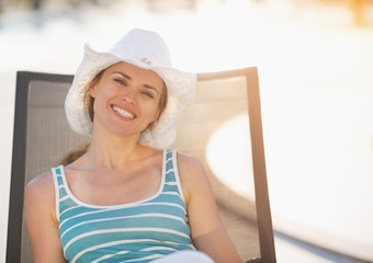 Happy woman laying on sun bed