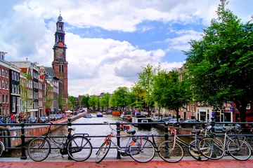 Fotobehang Amsterdam Fietsen langs een brug over de grachten van Amsterdam, Nederland