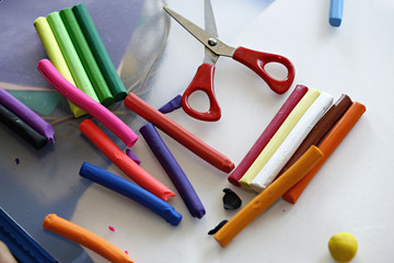 Colorful clay dough (plasticine) and scissors