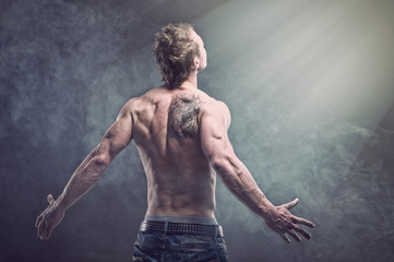 Fototapeta na wymiar Młody człowiek z tatuaż w dymie. Magia