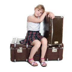The little girl on old suitcases