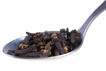 cloves on a spoon isolated on white background