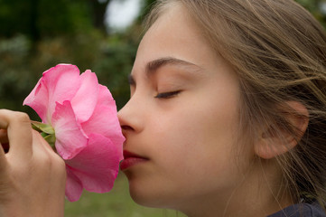 fillette sentant une rose