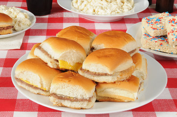 Platter of cheeseburgers on a picnic table