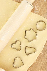 tins of cookies on the rolled out dough close-up