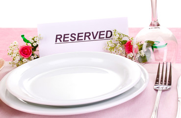 Table setting with reserved card in restaurant