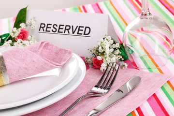 Table setting with reserved card in restaurant