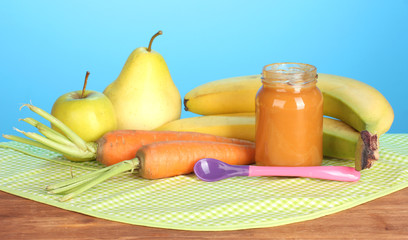 Jar with fruit and vegetables baby food, spoon and fruits and