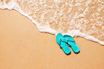 Fototapeta na wymiar Flip flops on the sand