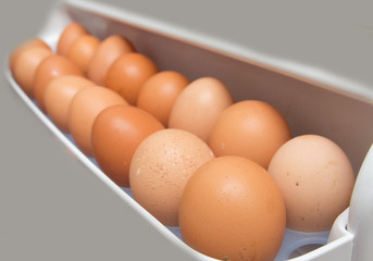 closeup of a pile of brown eggs in the fridge