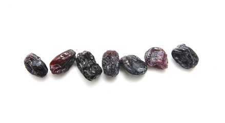 Black raisins set on white background.