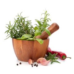 fresh flavoring herbs and spices in wooden mortar