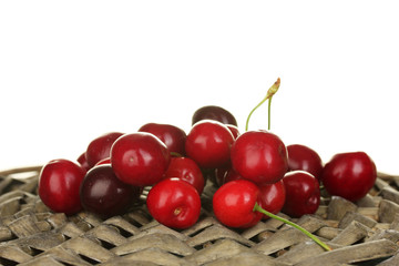 Cherry on the wicker cradle on white background close-up