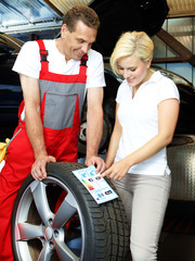 Motor mechanic explains to a customer tire labeling in a garage